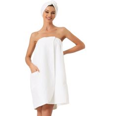 a woman in a white towel is standing with her hands on her hips and smiling