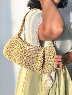 a woman holding onto a crocheted purse