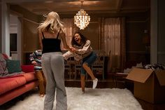 two women are dancing in the living room