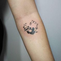 a small panda bear tattoo on the arm