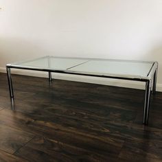 a glass table sitting on top of a hard wood floor