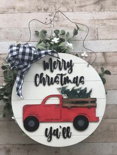 a sign that says merry christmas ya're with a red truck and pine tree