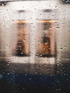 rain drops on the window with two buildings in the background