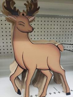 a wooden deer standing on top of a shelf