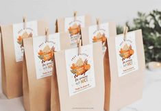 small brown bags with tags on them are sitting on a table next to a christmas tree