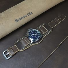 Leather cuff watch strap for men of High quality. Horween Chromexcel leather Bund band is durable, does not stretch, soft and elastic, comfortable and pleasant to the touch. Fits perfectly on your wrist and looks stylish, emphasizing the beauty of your watch. Compatible with watch case 18 mm, 20 mm, 22 mm, 24mm. Handmade watch band is a great gift for yourself or a loved one. #watchband #watchstrap #leatherwatchband #leathercuffwatchstrap #bundstrap #bundband #leatherbundstrap Handmade Adjustable Leather Watch Band, Rugged Leather Strap Watch Accessories, Vintage Cuff Watch With Leather Strap, Luxury Vintage Leather Strap Watch Band, Brown Cuff Leather Strap For Watch, Horween Chromexcel, Handmade Watch Bands, Leather Industry, Horween Leather