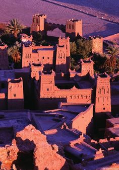 an aerial view of the desert with adobe buildings and palm trees