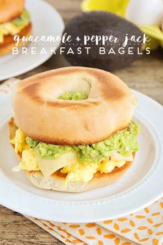 an egg and avocado bagel sandwich on a white plate