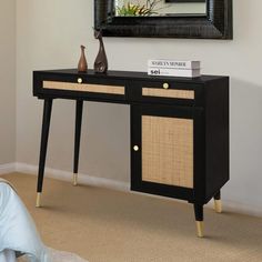 a black and gold console table with two vases sitting on it's side