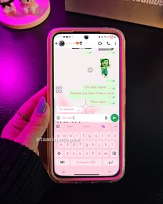 a person holding an iphone in their hand with the keyboard lit up on it's screen