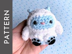 a small crocheted stuffed animal is held in someone's hand on a blue background