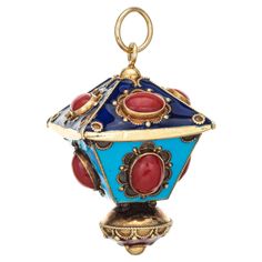 a blue and red glass ornament hanging from a gold plated metal hook