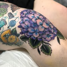 a woman's arm with tattoos and flowers on it