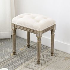 a white bench sitting on top of a rug