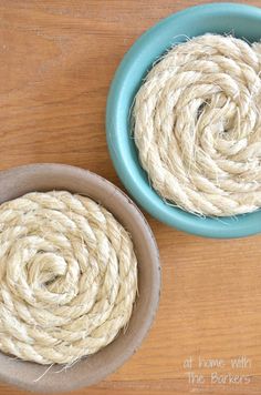 two bowls filled with twine on top of a wooden table