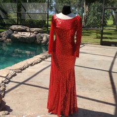 You Will Definitely Be The Lady In Red Show Stopper When You Make Your Entrance In This Beautiful Gown. This Gown Is Ornately Covered With Red Sequins And Is Fully Lined With Lightly Sheer Long Sleeves. This Gown Is Comfortably Stretchy While Designed To Hug Your Upper Body And Hips And End With A Soft Flare Almost Like A Layered Mermaid Style Bottom. It Has A Low Back But Has An Amazing Mid Back Strap Support Held On By 2 Snaps To Make Sure You Can Dance The Night Away. There Are Also Three Eye Red Festive Evening Gown, Red Fitted Gown With Long Sleeves, Red Fitted Long Sleeve Gown, Red Long Sleeve Gown For Holidays, Red Long Sleeve Holiday Gown, Red Sequined Holiday Gown, Red Festive Maxi Dress For Prom, Festive Red Maxi Dress For Prom, Holiday Red Sequined Gown