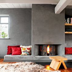 a living room filled with furniture and a fire place next to a wall mounted fireplace