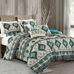 a bed covered in a blue and white comforter next to a wooden headboard