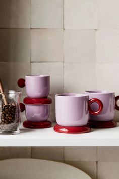 cups and saucers are lined up on a shelf