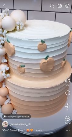 a three layer cake with white frosting and peaches on top, surrounded by eggs