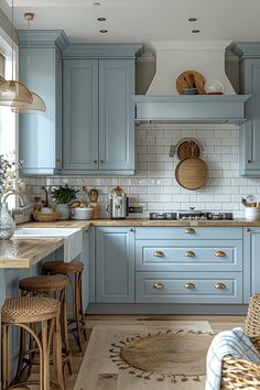 a kitchen with blue cabinets and wooden stools