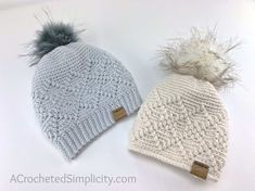 two knitted hats with pom - poms are shown on a white surface