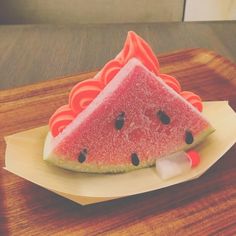 a slice of watermelon on a plate with ice cream and black dots around it