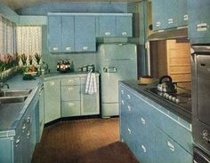 an old fashioned kitchen with blue cabinets and wood floors