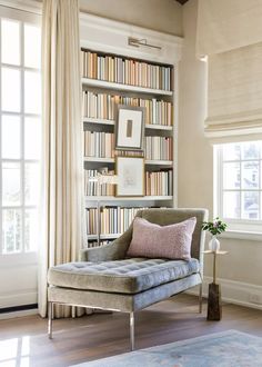 a chair in front of a book shelf filled with books