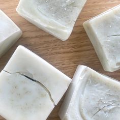 four pieces of soap sitting on top of a wooden table