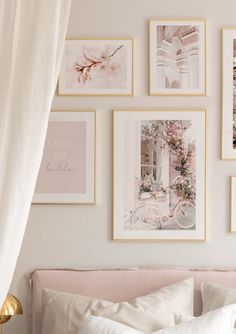 a bed with white sheets and pictures on the wall