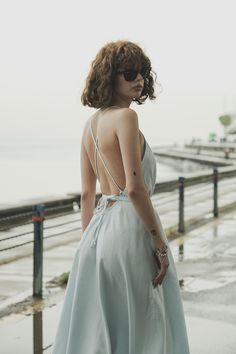 Our stylish, must-have version of the essential LBD (little ​beach dress), the Sage Maxi Dress Baby Blue is a flowing asymmetric dream that’s perfect for mid-summer events, beach days, and travel. The silhouette is inspired by the tranquil vibes of Tulum’s beaches and bustling energy of its town center. It features long straps you can wrap twice around the waist for an adjustable fit. Breathable fibers keep you cool as you lounge, explore, and indulge all summer long. Summer V-neck Backless Dress For Day Out, Chic Backless Maxi Dress For Summer, Chic Summer Backless Midi Dress, Chic Backless Summer Midi Dress, Flowy Breezy Summer Dress, Flowy Midi Dress For Summer Beachwear, Breezy Summer Midi Dress With Spaghetti Straps, Breezy Spaghetti Strap Midi Dress For Summer, Chic Backless Sundress For Beach