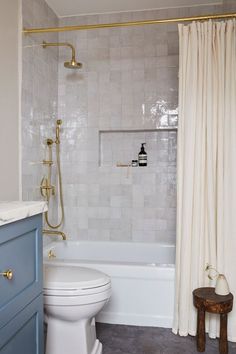 a white toilet sitting next to a bath tub in a bathroom under a shower curtain