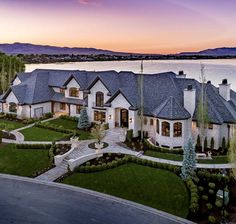 this is an aerial view of a luxury home by the water at sunset or dawn