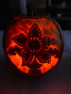 a carved pumpkin with an intricate design on it's face is shown in the dark