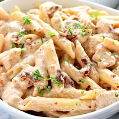 a white bowl filled with pasta and chicken