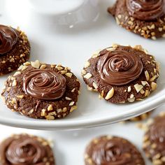 cookies with chocolate frosting and nuts on a plate