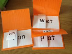 three orange pieces of paper with words cut out on them sitting next to each other