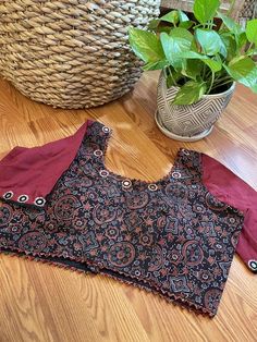 A beautiful hand block printed (Ajrakh) pure cotton blouse in sizes 40 and 42 with hand embroidered mirror (authentic mirror- not mica) with elbow sleeves. The body has the ajrakh print in a black base while the sleeves are in contrast - dark maroon. Blouse is padded with hook in the back. Front and back both are U shaped neckline. Extra margin available to increase up to one size. You may reach out to us for alterations. Size change is a $5 extra charge. Note: We try to stay as accurate to the Red Block Print Cotton Blouse Piece, Red Cotton Block Print Blouse Piece, Red Cotton Block Print Blouse, Traditional Cotton Blouse Piece With Kalamkari Print, Festive Cotton Bandhani Print Blouse Piece, Festive Cotton Bandhani Blouse Piece, Traditional Cotton Blouse With Bandhani Print, Unstitched Bohemian Cotton Blouse Piece, Cotton Blouse Piece With Bandhani Print For Navratri