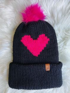 a knitted hat with a pink heart on it