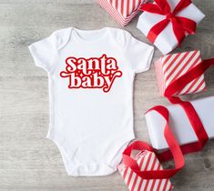 Introducing our "Santa Baby Christmas White Bodysuit for Babies," a charming and festive addition to your little one's holiday wardrobe! Key Features: Design: Adorable "Santa Baby" message in festive red and green colors, perfect for capturing the playful and joyful spirit of Christmas. Material: Soft and gentle fabric for ultimate comfort, ensuring a cozy feel against baby's delicate skin. Fit: Classic bodysuit design with snap closures for easy diaper changes and a secure fit. Versatility: Ide Birthday Wine Glasses, Whimsical Santa, Baby 12 Months, Baby Messages, Christmas Baby Announcement, Christmas Bodysuit, Meet Santa, Wedding Wine Glasses, Fun Ornaments