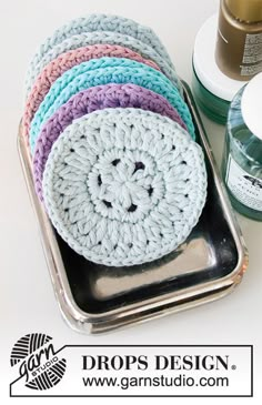 there are many crocheted items in the tins on the table with it's lid open