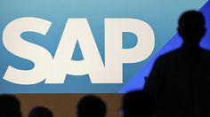 the silhouette of a man standing in front of a sap sign with people watching him