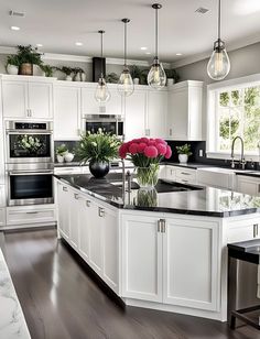 a large kitchen with white cabinets and black counter tops, along with an island in the middle