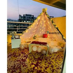 a bed decorated with flowers and balloons on top of a roof at night or dawn