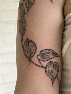 a close up of a person's arm with a flower tattoo on the side