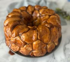 a bundt cake sitting on top of a white plate covered in caramel sauce