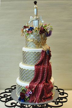 a three tiered wedding cake decorated with flowers and ribbons