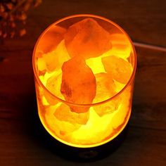 a glass filled with ice sitting on top of a wooden table