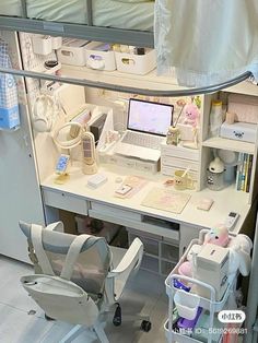 a white desk with a laptop computer on top of it next to a chair and other items